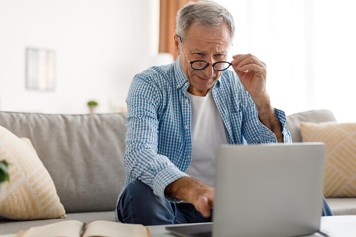 Man having a hard time reading his computer