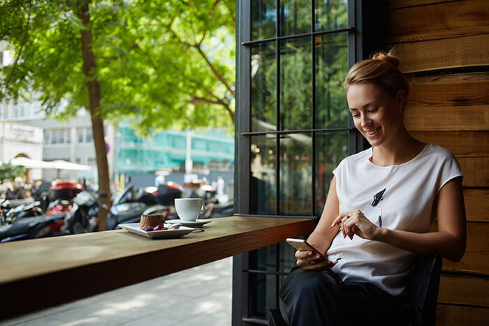 Woman smiling while looking at her mobile phone